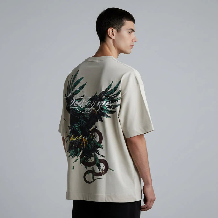 Beige t-shirt with a black and green eagle design on a dark background